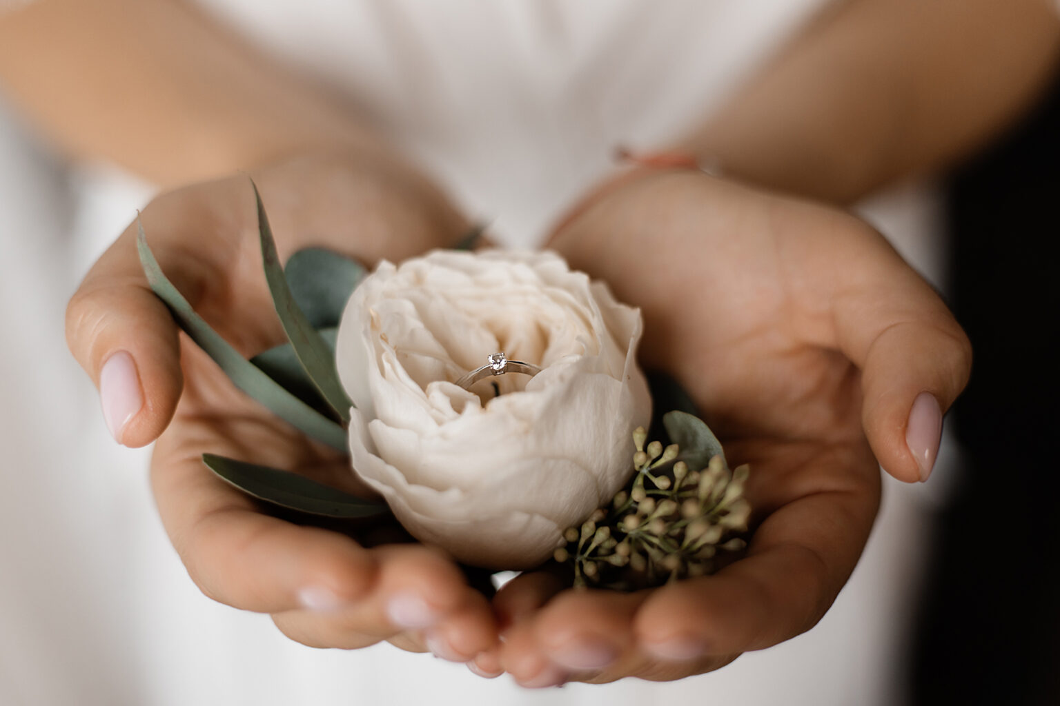 Tender eustoma flower with engagement ring with tiny diamond in